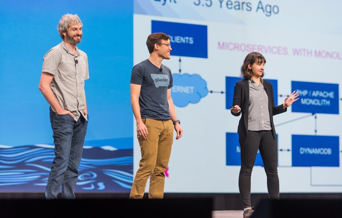 People discussing diagrams on a conference stage